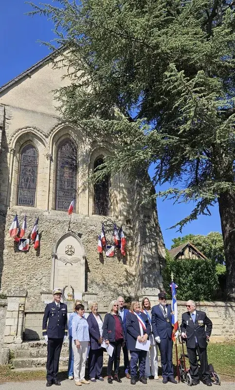 Cérémonie commémorative devant l'église pavoisée aux couleurs tricolores.