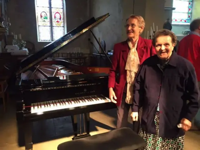 Piano à queue et personne en rouge