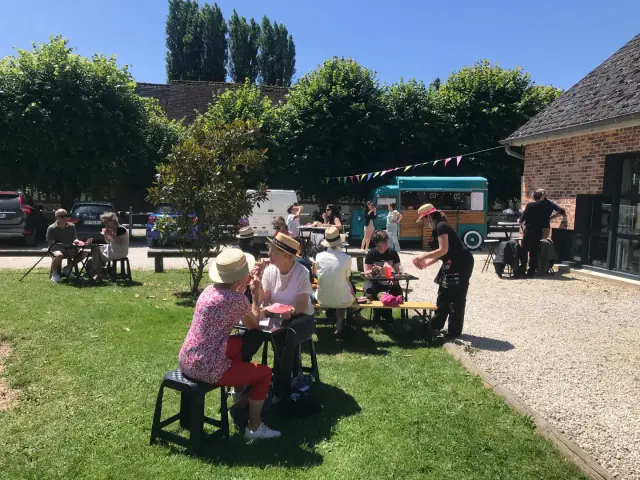 Fête de la Peinture : les tables des participants installées dans le jardin, sous les guirlandes