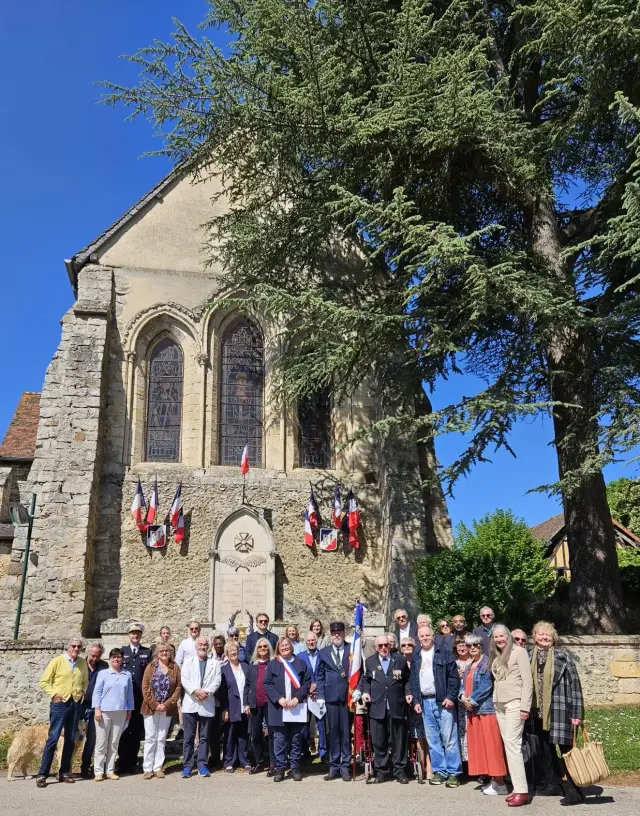 Photo de groupe des habitants et élus devant l'église pavoisée